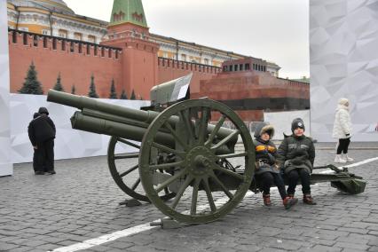 Москва. Дети сидят на пушке на территории интерактивного музея под открытым небом на Красной площади. Музей посвящен параду 7 ноября 1941 года.