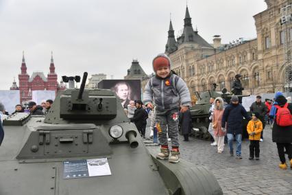 Москва. Мальчик стоит на советском танке Т-60 на территории интерактивного музея под открытым небом на Красной площади. Музей посвящен параду 7 ноября 1941 года.