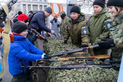 Красноярск. Празднование Дня народного единства на площади Революции. Мальчик рассматривает оружие.