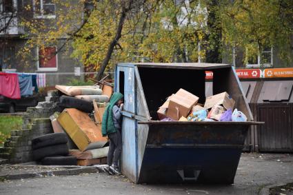 Калининград. Виды города. Мальчик заглядывает в мусорный контейнер.