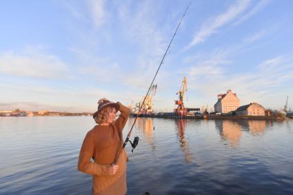 Калининград. Девушка ловит рыбу  на городской набережной.