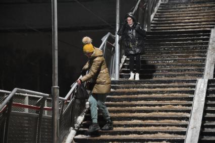 Москва. Люди спускаются по лестнице во время ледяного дождя на железнодорожном вокзале.