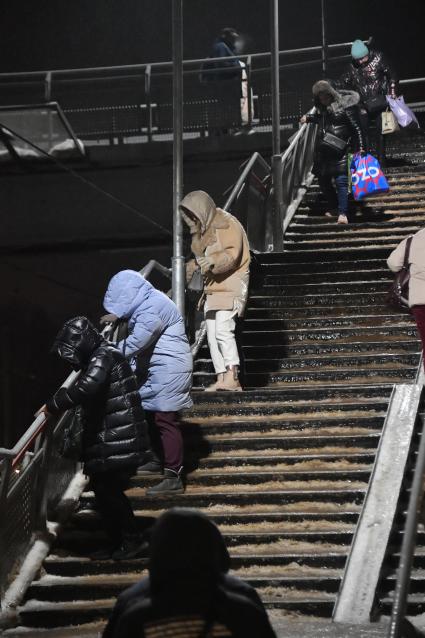 Москва. Люди спускаются по лестнице во время ледяного дождя на железнодорожном вокзале.