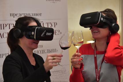 Москва. Посетительницы в VR-очках дегустируют вино на первом Российском винодельческом форуме в отеле Radisson Collection.