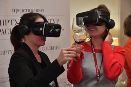 Москва. Посетительницы в VR-очках дегустируют вино на первом Российском винодельческом форуме в отеле Radisson Collection.