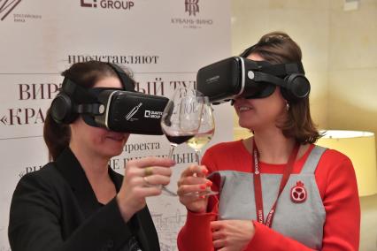 Москва. Посетительницы в VR-очках дегустируют вино на первом Российском винодельческом форуме в отеле Radisson Collection.