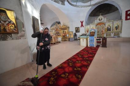 Москва.  Женщина моет пол в храме Великомученицы Ирины в Покровском.