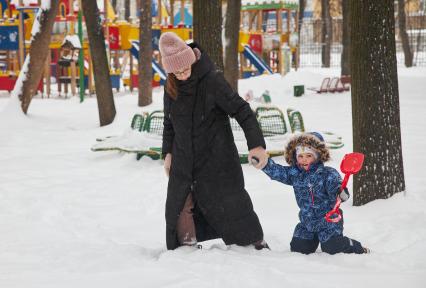 Пермь. Женщина гуляет с ребенком на детской площадке.