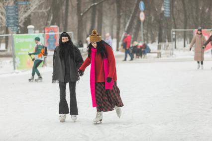 Москва. Девушки катаются на коньках в парке `Сокольники`.