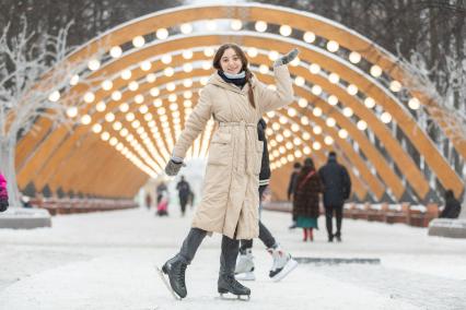 Москва. Девушка катается на коньках в парке `Сокольники`.