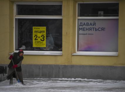 Свердловская область. Нижний Тагил. Корреспонденты `Комсомольской правды` Владимир Ворсобин и Иван Макеев путешествуют автостопом по России.  Женщина убирает снег на улице.