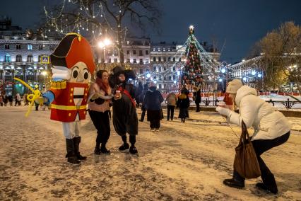 Санкт-Петербург. Люди фотографируются с ростовыми куклами на Рождественской ярмарке на Манежной площади.