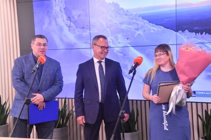 Москва. Заместитель главного редактора, шеф-редактор ежедневного выпуска газеты `Комсомольская правда` Евгений Сазонов (слева) и победитель фотоконкурса Елена Соколова во время награждения победителей фотоконкурса имени Василия Пескова`Окно в природу` в редакции `Комсомольская правда`.