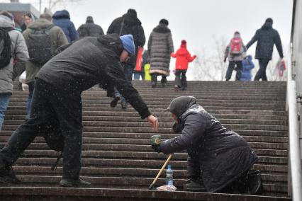 Москва. Пожилая женщина просит милостыню у подземного перехода.