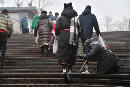 Москва. Пожилая женщина просит милостыню у подземного перехода.