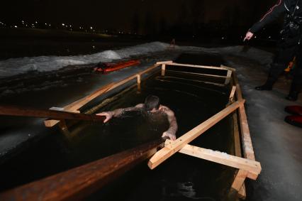 Санкт-Петербург. Мужчина окунается в купели во время ночных крещенских купаний.