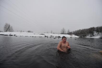 Московская область. г.Пушкино. Мальчик окунается в реке Уча во время крещенских купаний.