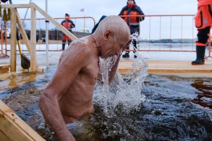 Санкт-Петербург.  Мужчина во время празднования Крещения у стен Петропавловской крепости.