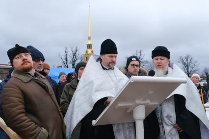 Санкт-Петербург.  Священнослужитель проводит чин освящения воды во время празднования Крещения у стен Петропавловской крепости