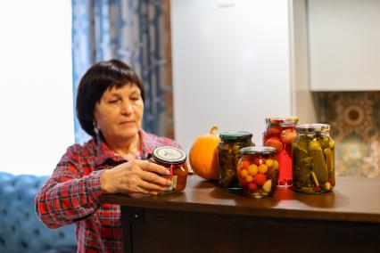 Красноярск. Пожилая женщина показывает домашние заготовки и соленья в своем загородном доме.