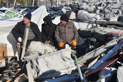 Турция. Провинция Кахраманмараш. Последствия разрушительного землетрясения. Местные мужчины среди завалов.