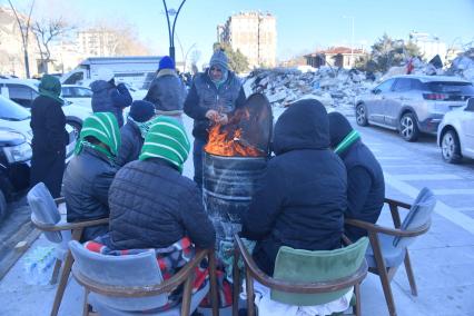 Турция. Провинция Кахраманмараш. Последствия разрушительного землетрясения. Местные жители, оставшиеся без домов, греются у костра.