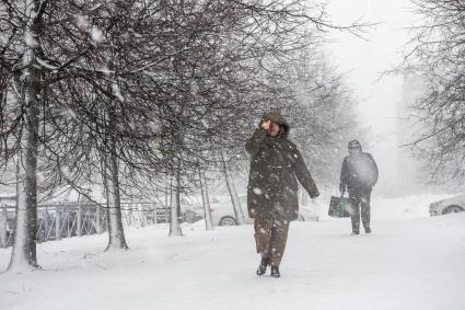 Санкт-Петербург. Женщина во время снежного шторма на улице города.