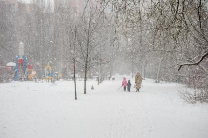 Санкт-Петербург. Женщина с детьми в парке во время снежного шторма.