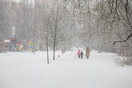 Санкт-Петербург. Женщина с детьми  в парке во время снежного шторма.