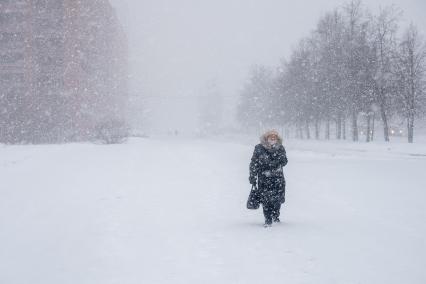 Санкт-Петербург. Женщина во время снежного шторма на улице города.