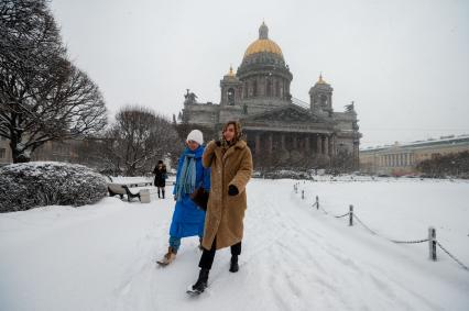 Санкт-Петербург. Девушки у Исаакиевского собора во время снежного шторма.