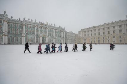 Санкт-Петербург.  Школьники на экскурсии на Дворцовой площади во время снежного шторма.