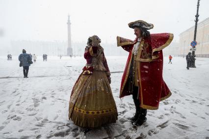 Санкт-Петербург. Мужчина и женщина  в исторических костюмах на Дворцовой площади во время снежного шторма.