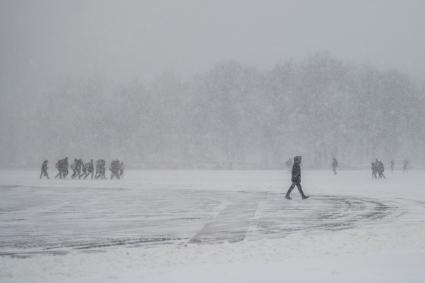 Санкт-Петербург.  Прохожие на Дворцовой площади во время снежного шторма.