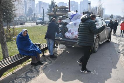 Турция. Провинция Кахраманмараш. Последствия разрушительного землетрясения. Местные жители грузят вещи в багажник автомобиля.