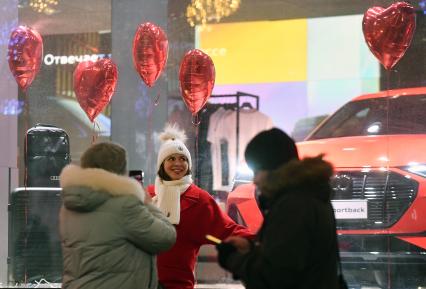 Москва. Празднование Дня всех влюбленных. Девушка фотографируется на фоне автомобиля Audi.