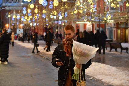 Москва. Молодой человек с букетом цветов в День всех влюбленных на Никольской улице.