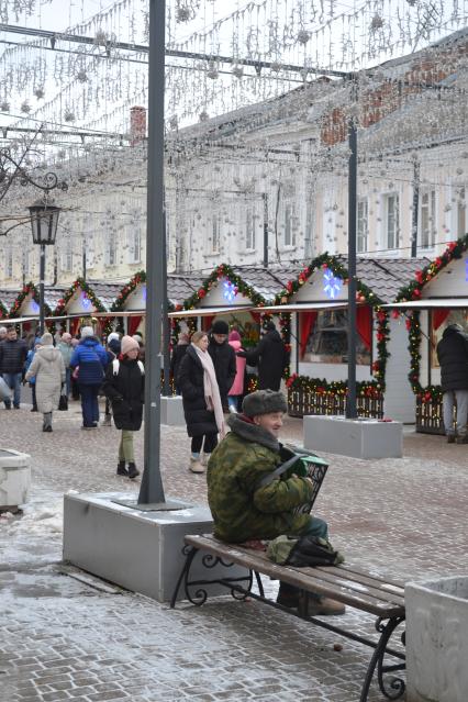 Москва. Пожилой мужчина в военной форме играет на праздничной ярмарке.