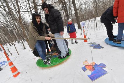 Москва. Городской Центр дополнительного образования `Лаборатория путешествий` празднует `День Арктики` в парке Сокольники. Дети играют в игру `Рыбалка на льдине`.