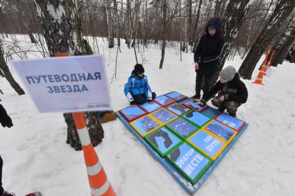 Москва. Городской Центр дополнительного образования `Лаборатория путешествий` празднует `День Арктики` в парке Сокольники. Дети играют в игру `Путеводная звезда`.