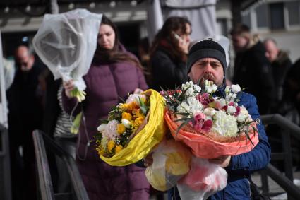 Москва. Мужчина с букетами цветов около Рижского цветочного рынка в преддверии праздника 8 Марта.