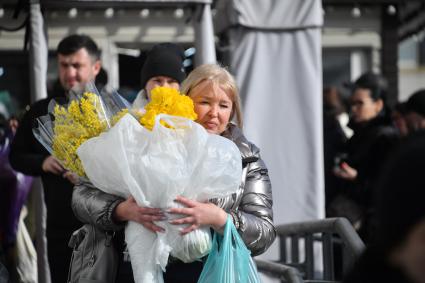 Москва. Женщина с цветами около Рижского цветочного рынка в преддверии праздника 8 Марта.