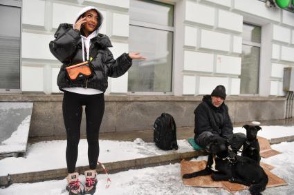 Москва.  Девушка  разговаривает на улице по мобильному телефону.