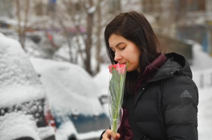 Москва.  Женщина с букетом тюльпанов  в международный женский день 8 Марта.