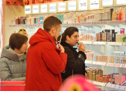 Москва. Покупатели выбирают духи в магазине в международный женский день 8 Марта.