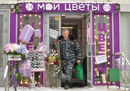 Москва.  Мужчина с букетом цветов в международный женский день 8 Марта.