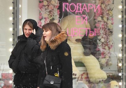 Москва. Девушки у  витрины магазина  в международный женский день 8 Марта.