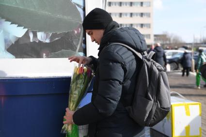 Москва. Мужчина с букетом цветов в преддверии праздника 8 Марта.