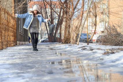 Красноярск. Девушка идет по дороге во время гололеда.