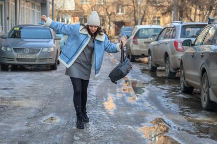 Красноярск. Девушка идет по дороге во время гололеда.